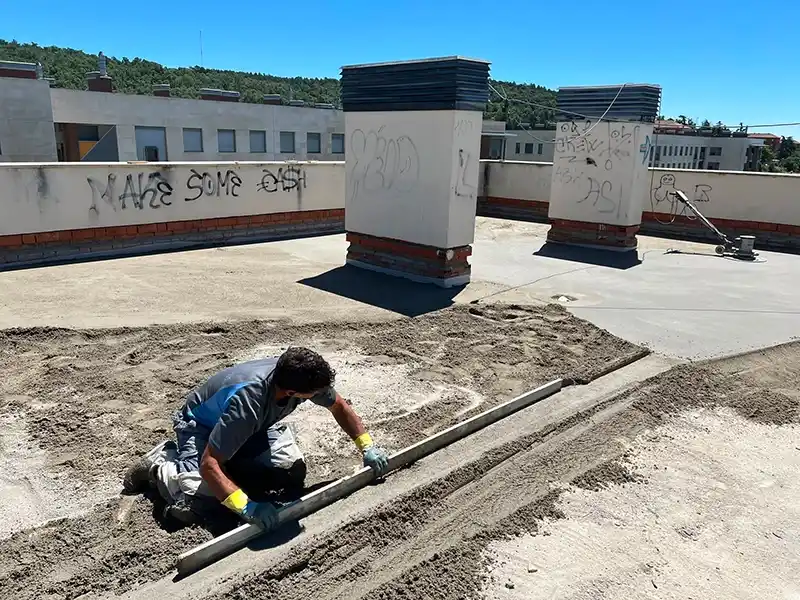 Trabajador haciendo un trabajo de formación de pendientes en azotea.